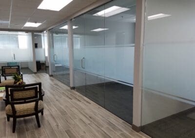 Modern office lobby with glass doors and chairs.