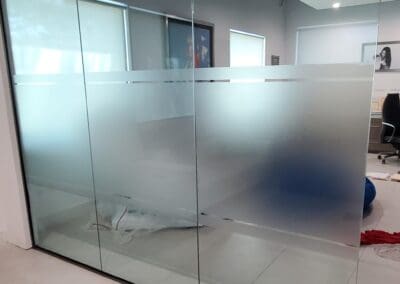 Glass partition with frosted panels in an office setting.